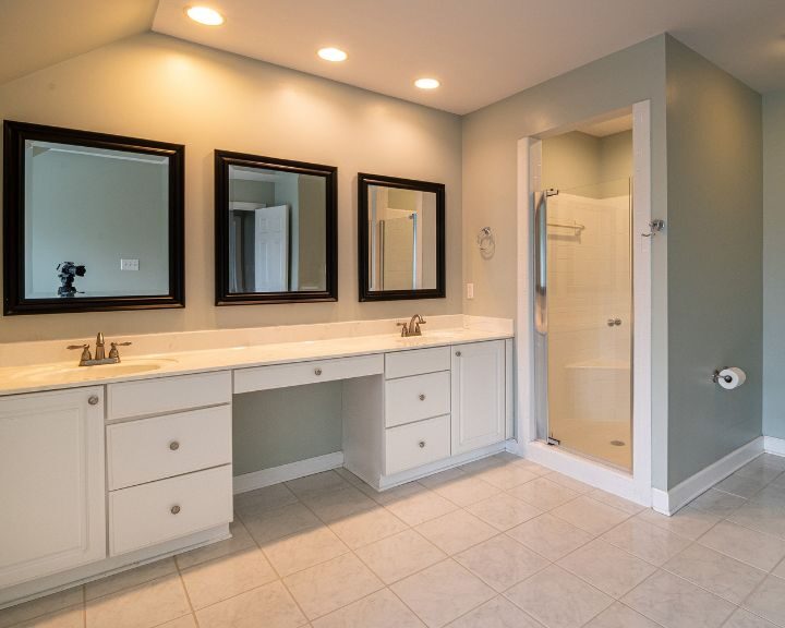 A bathroom remodel with dual sinks and cabinets.