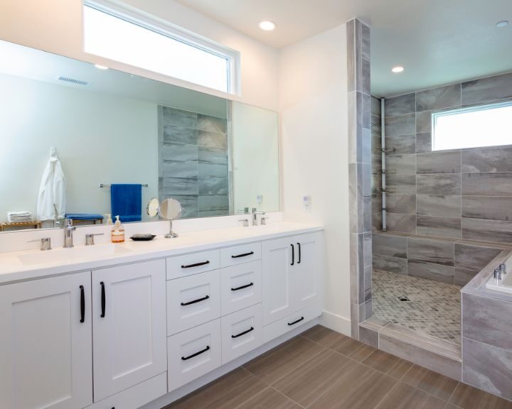 A contemporary bathroom with white cabinets and a walk-in shower in the city.