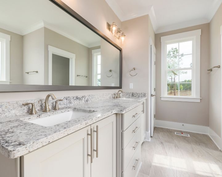 A bathroom with two sinks and a mirror featuring countertops.