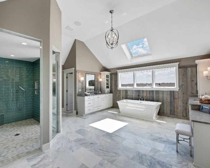 A large bathroom design with a skylight and marble floors.