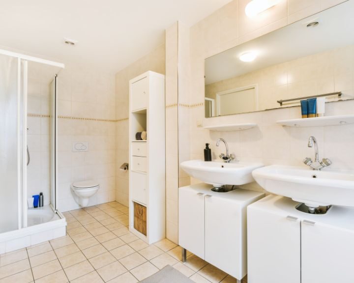 A modern bathroom design in the city with two sinks and a shower stall.
