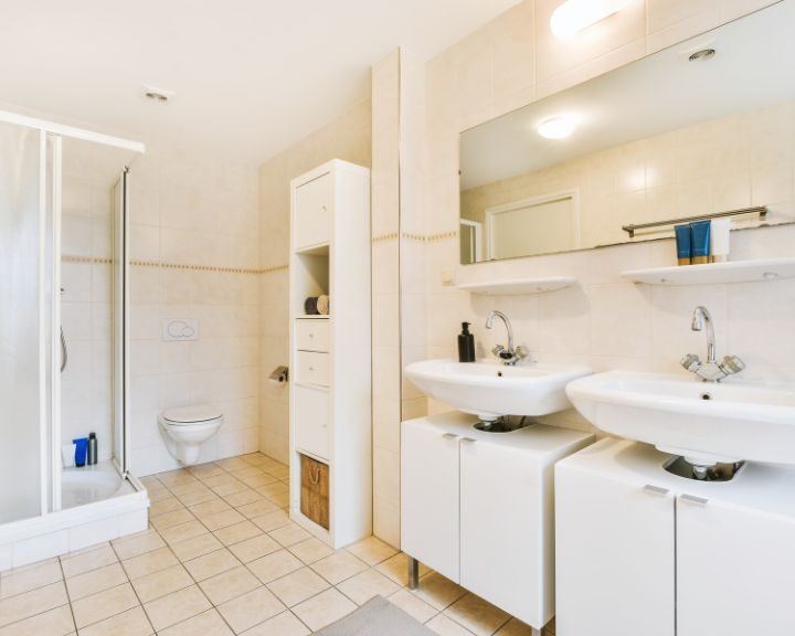 A bathroom with two sinks and a shower stall.