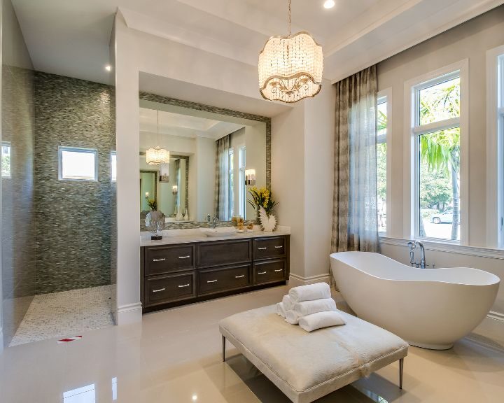 A luxurious bathroom with a large tub and a chandelier in the Waterbury.